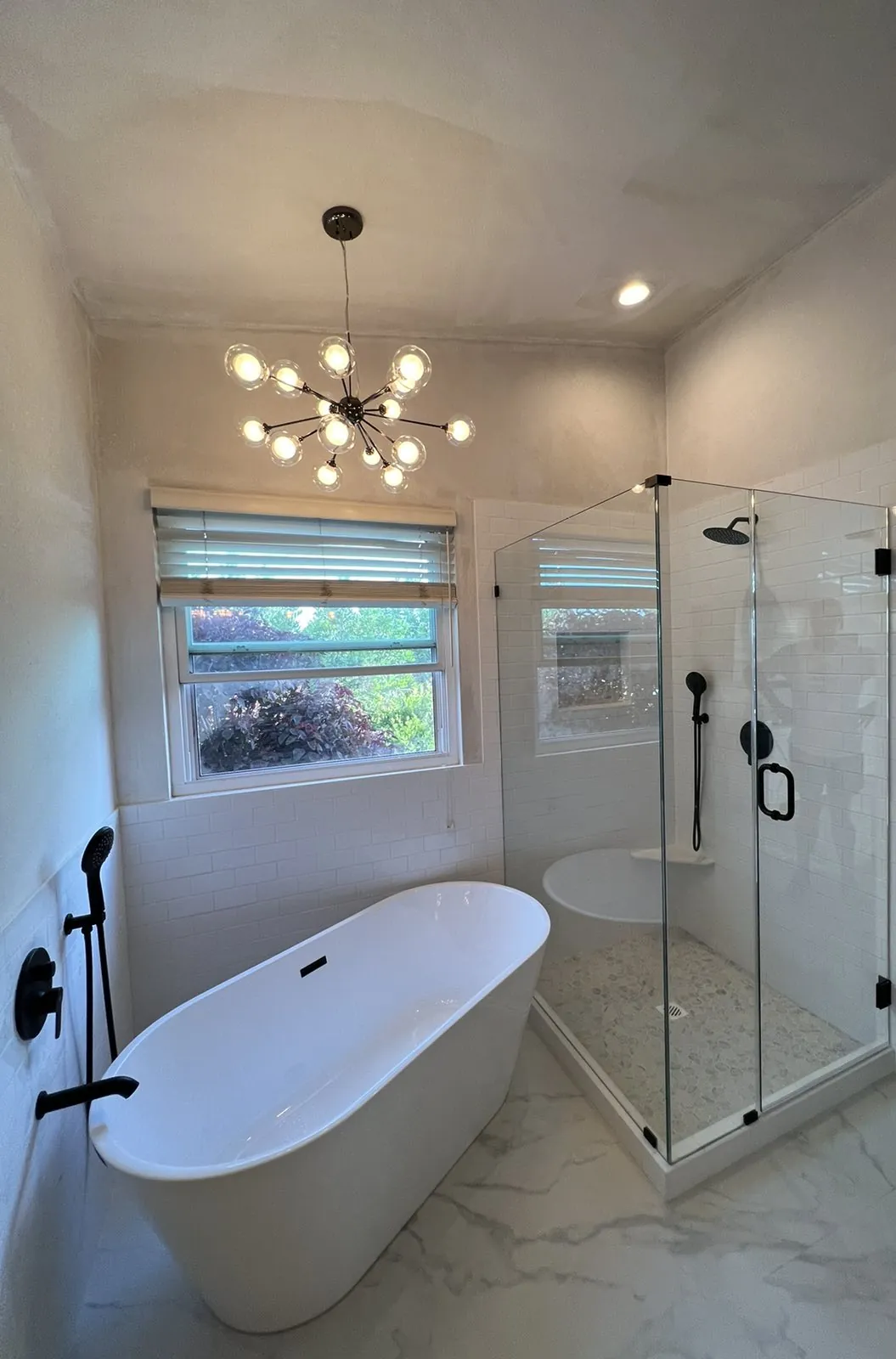 Primary bathroom with a freestanding tub and frameless glass shower